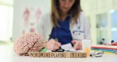 Bir sağlık uzmanı sinirsel tikleri anatomik modeller ve özel tıbbi araçlarla inceliyor.