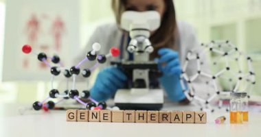 Bir bilim adamı örnekleri mikroskopla inceleyerek gen terapisindeki gelişmeleri ve uygulamalarını vurguluyor.