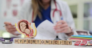 Bir tıp uzmanı araştırmaları sırasında anatomik bir modele odaklanırken hipertonikliği inceliyor.