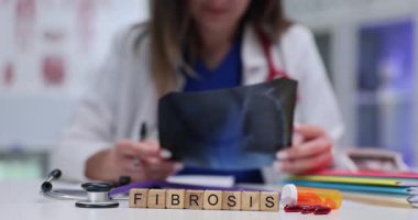Bir sağlık uzmanı, klinik bir ortamda fibrozis belirtileri aramak için röntgeni dikkatlice inceler.