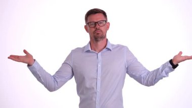 Bir adam, beyaz bir arkaplan karşısında ellerini açık tutarak kafa karışıklığı ya da belirsizlik hissi gösterir.