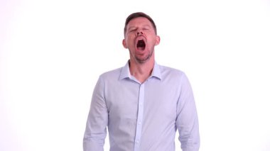 Geniş bir alanda esneyen bir adam, beyaz bir arka plana karşı yoğun yorgunluk ifadesi sergiliyor.