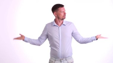 Açık renkli bir gömlek giymiş bir adam, kollarını açmış, hem kendine güvenini hem de açıklığını ifade ediyor.