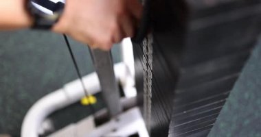 Kendini spora adamış bir insan spor makinesine ağırlık verip spor yapmaya ve günlük egzersize bağlılığını gösterir.