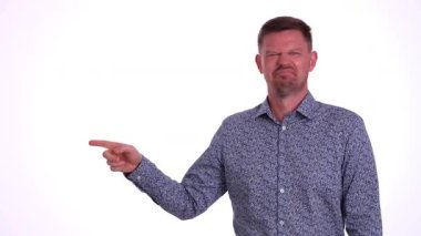 Bir adam, gücenmiş bir ifade sergilerken, çok özel bir yönü işaret ederek niyetini belli eder.