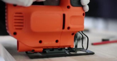 Testereli işçiler atölyedeki tahta delikte delik açtılar. Marangoz ahşap atölyesinde elektrikli alet kullanıyor.