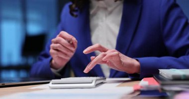 Kadın, şirket giderlerini hesap makinesinden hesaplıyor. İş kadını, kurumsal ofiste ağır çekimde mali dengeyi kontrol etmek için elektrikli cihaz kullanıyor.