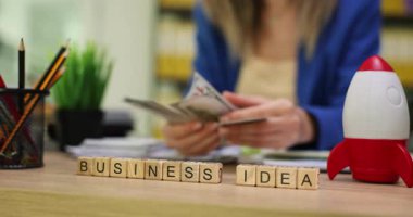 İş yerinde para sayan kadınlara karşı Küpler 'den gelen iş görüşü. İş kadını banknotları tutar anlaşma için para hazırlar