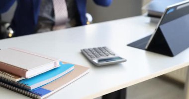 Ofis çalışanı kulaklık takar ve el kol hareketleri yaparak dans etmeye başlar. Mavi ceketli, neşeli bir adam masada oturup tablet izliyor.