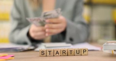 Kadın girişimci masaya oturur ve dolarları dikkatle sayar. Tecrübeli iş kadını parayı Startup projesi için kullanmayı planlıyor. Yavaş çekim