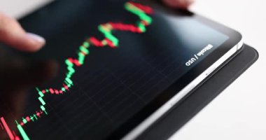 İş kadını tablet ekranda gösterilen mali tabloları inceliyor. Kadın ofis çalışanı, yükselen ve düşen borsa eğilimlerini analiz ediyor