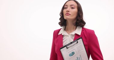 Parlak pembe ceketli kadın elinde bir panoyla büyüteçle dikkatlice bakıyor. Hanımefendi şüpheli nesneleri yakından inceliyor.