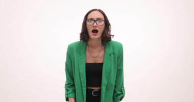 Kadın şaşırmış ve şok olmuş bir ifadeyle dikkatle bakarken bardakları burnunun ucuna indiriyor. Açık ağız ve geniş gözler ani şaşkınlığı vurgular.