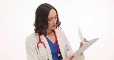 Konsantre kadın doktor, beyaz arka plandaki hastanın test sonuçlarını inceliyor. Doktor, laboratuvar raporunu panoda tutuyor. Yavaş çekim