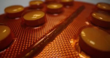 Portakal desenli kabarcık ve beyaz masada ilaç. Tezgahta hasta tedavisi için reçeteli eczane paketi var. Vitamin takviyesi