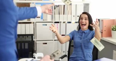 Mavi elbiseli adam kollarını açmış gülen bir kadının yanına para atıyor. Banknotlar, ofisteki ödüllendirme anlarını öneren insanların etrafında toplanıyor