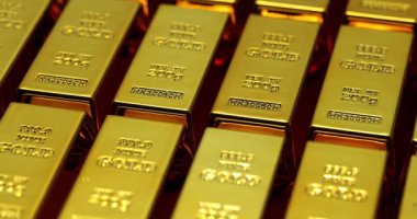 Bankanın yüksek güvenlikli kasasında altın külçeler mükemmel bir sıra oluşturur. SIC işaretli cilalı altın yüzey bankanın yapay ışıklandırması altında parlıyor