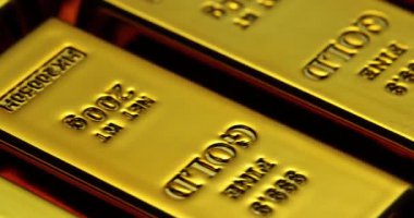 Finans kurumunun depolarında düzenli olarak birikmiş altın külçeleri. Altın külçelerinin yansıtıcı yüzeyleri, sönük tonoz ışığı altında pullarla parıldıyor.