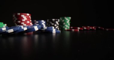 Masanın yüzeyine rengarenk kumarhane fişleri ve zarlar yerleştirilmiş. Poker çipleri ve kırmızı zarlar dağıtıcının bir sonraki hamlesini bekleyin