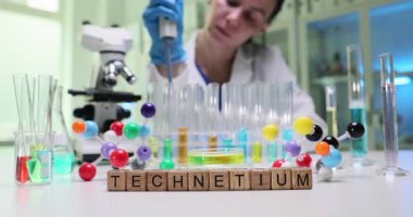Kendini adamış bir araştırmacı canlı ve renkli bir laboratuvar ortamında Technetium örneklerini dikkatlice inceler.