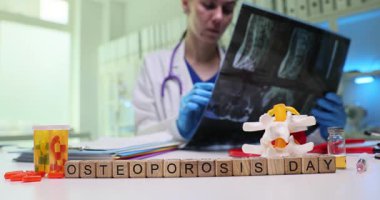 Bir sağlık uzmanı, Osteoporoz Günü için farkındalığı artırmak ve eğitimi desteklemek amacıyla Xray resimlerini gözden geçiriyor
