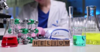 Canlı renkli sıvıların ve karmaşık moleküler modellerin yer aldığı kesme kaplamalı helyum araştırması.
