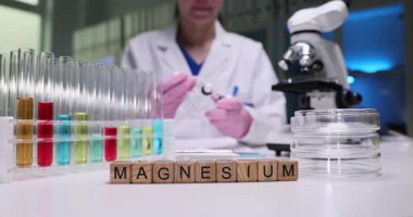 Bir laboratuar teknisyeni farklı reaksiyonları analiz etmek için magnezyum ve renkli test tüpleriyle deneyler yapar.