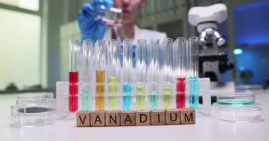 Yetenekli bir laboratuar teknisyeni test tüplerinde renkli vanadyum çözeltileriyle karmaşık deneyler yapar.