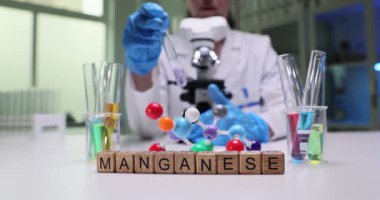 Kendini işine adamış bir bilim adamı, laboratuarda manganez ve renkli sıvılarla yenilikçi bir deney yapıyor.