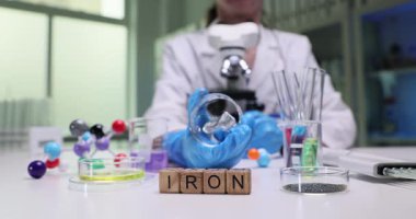 Bir bilim adamı, yüksek teknoloji laboratuvarında gelişmiş ekipmanlarla demir örneklerini inceleyerek analiz sırasında doğruluğu garanti altına alıyor.