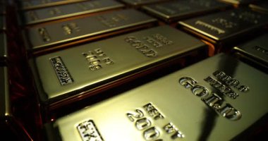 Güzelce istiflenmiş altın külçeleri sıcak ışığı yansıtıyor zenginlik ve bolluk atmosferi yaratıyor. Değerli metallerin cazibesi ve yatırım değeri