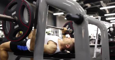 Güçlü sporcu ağırlık kaldırarak ağırlık kaldırma egzersizi yapıyor. Sağlıklı yaşam tarzını destekleyen spor salonunun dayanıklılığı ve kondisyonuna bağlılık
