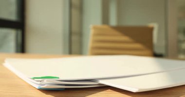 Evrak organizasyonu ahşap masada bir araya toplanmış. Tezgahtar işyerinde şirket belgelerini üst üste yığmak. İş evrakları. Çerçeve kırmak