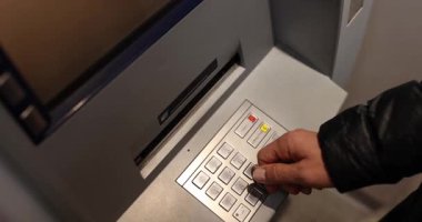 İnsan eli, akşam vakti ATM 'den dolar alır. Müşteri, hesap erişiminin güvenli ve kullanışlı sürecini vurgulayarak nakit çekti
