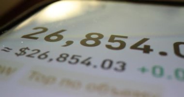 Akıllı telefon ekranında hisse senedi piyasası değişen veriler ve finansal rakamlar gösteriliyor. Eğilimleri kontrol etmek için mobil uygulama yoluyla yatırım bilgilerinin analiz edilmesi