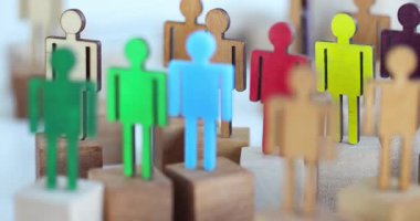 Renkli ahşap figürler, çeşitlilik kavramlarını sembolize eden blokların üzerinde duruyorlar. Topluma dahil olmanın faydaları ve temsil edilmenin önemi