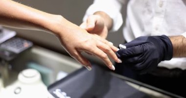 Mücevher, müşterinin parmağına takılan pırlanta yüzüğü dikkatlice yerleştirir. Mücevher mağazası çalışanı kesimi ve elmas yavaş çekimin berraklığını açıklıyor