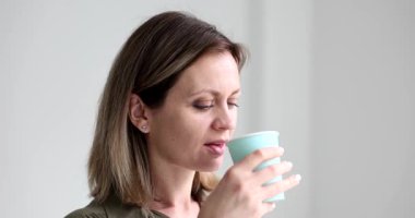 Ofis çalışanı tek kullanımlık bardaktan ferahlatıcı içeceğin tadını çıkarıyor dinlenmek için hak ettiği molayı alıyor. Modern ofiste yoğun çalışma gününde şarj olmak