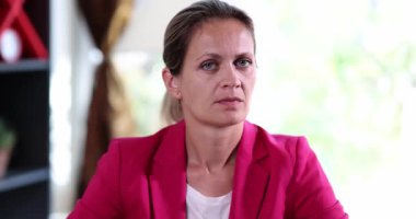 Beyaz gömlek üzerinde pembe ceketli bir iş kadını başını sallamayı reddediyor. Bayan gösteri yapıyor. Ofiste otururken ciddi bir ifadeyle hareket etmeyi kesin.