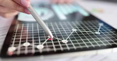 Bayan, masadaki dijital tablette finansal tabletleri analiz ediyor. Kadın tüccar, pazar eğilimlerini değerlendirdi yatırımları değerlendirdi çemberler ve çapraz