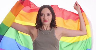Genç bir kadın, LGBTQ 'nun kabulünü temsil eden gökkuşağı bayrağı taşıyor. Esmer, neşeli ifadeli kadın olay sırasında eşitliğe destek veriyor