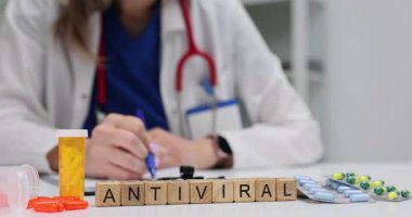 Tahta küplerden antiviral 'e doktor iş yerindeki çeşitli haplarla mesaj at. Terapist, bulaşıcı hastalıkları tedavi etmek için ilaçlar yazıyor.