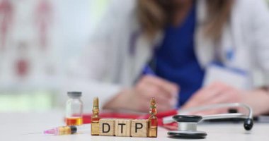 Tahta küplere DTP, aşı şişeleri ve doktor masasında şırınga. Kadın doktor difteri tetanos ve pertusisin test sonuçlarını kontrol ediyor.