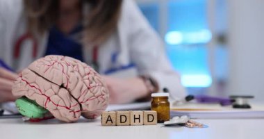 Kadın doktor hiperaktivite tedavisi için reçete yazıyor. Beyin modelleme hapları ve steteskopla. Nörolojik yönler ve ilaç seçenekleri