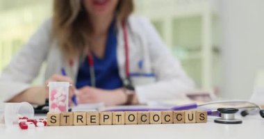 Kadın doktor, Streptococcus bakteriyel enfeksiyonları ilaç ve steteskopla tedavi etmek için reçete yazıyor. Temel sağlık hizmetleri