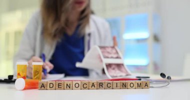 Doktorun ultrason taramalarını incelemesine karşı ahşap küp Adenokarsinom. Kadın terapist hastane iş yerindeki test sonuçlarını kontrol ediyor.