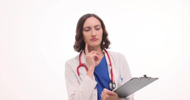 Beyaz önlüklü dalgın kadın doktor, teşhisi açık arkaplanda düşünüyor. Dosyası olan doktor tıbbi konsültasyon ve tedavi planlıyor