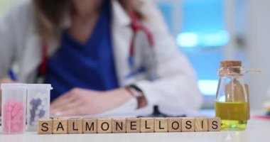 Profesyonel kadın Salmonelloz teşhisi yazıyor. Tıbbi geçmişinde küplere koyulmuş. Masanın yanındaki hapların yanında. Hastanede hasta bakımı ve tedavi seçenekleri