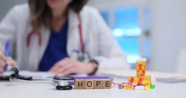 Doktor masasında ilaç olan tahta küplerin Hope 'a mesaj at. Tıbbi uzman, hastanede iyileştirme ve olumlu sonuç sunan reçeteler yazıyor.