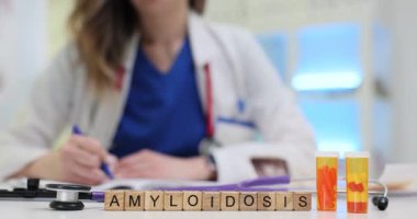 Kadın doktor, masadaki ilaç şişelerinin yanında amiloidoz tedavisi için reçete yazıyor. Klinik ortamında kapsamlı hasta yönetimi